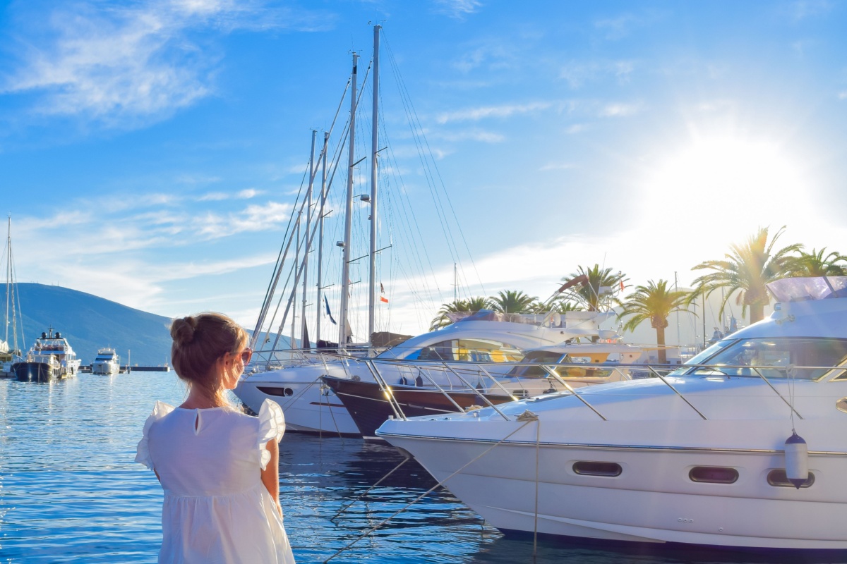 Woman looking at luxury yachts in a marina