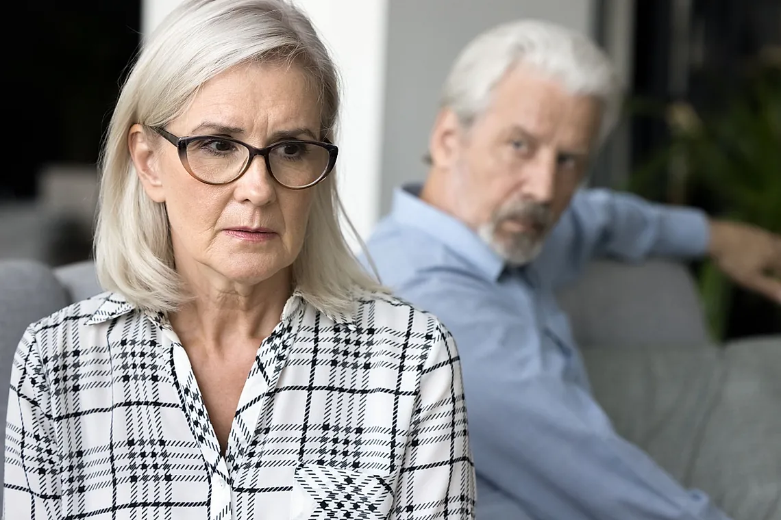 woman looking worried as her husband looks at her 