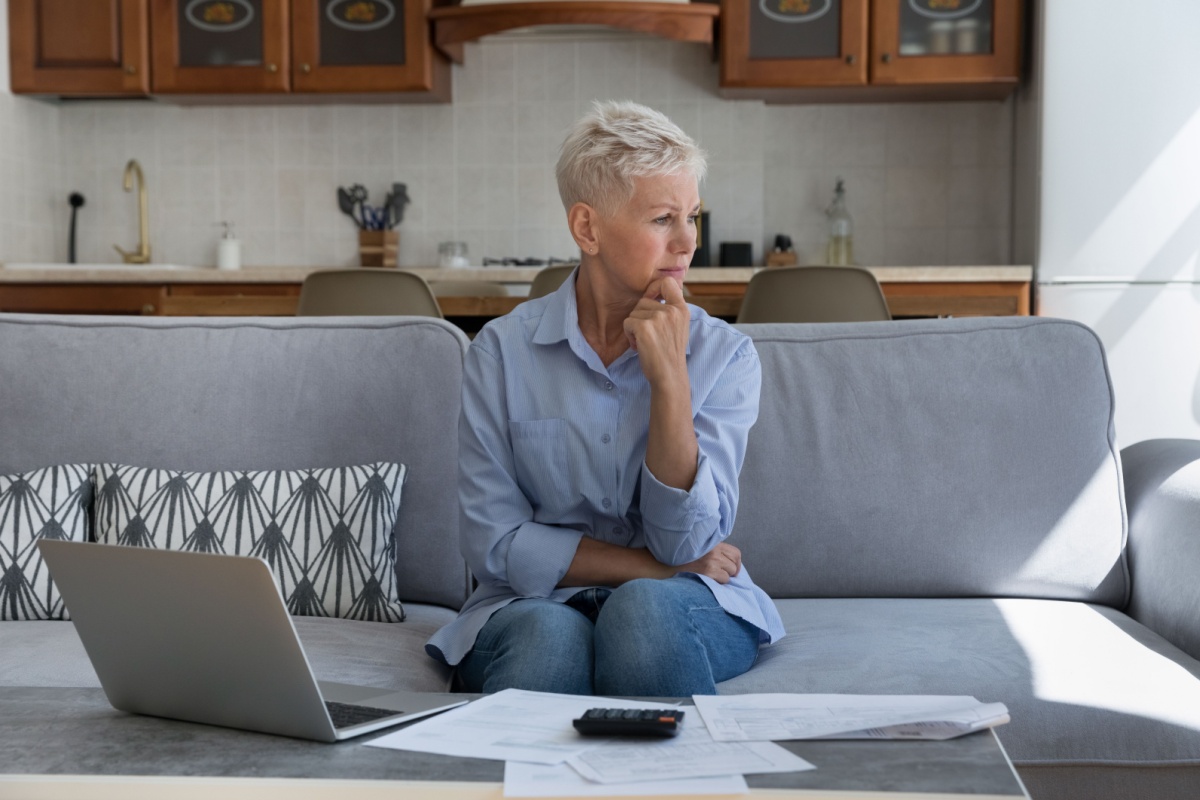 Thoughtful mature woman looking at financial paperwork