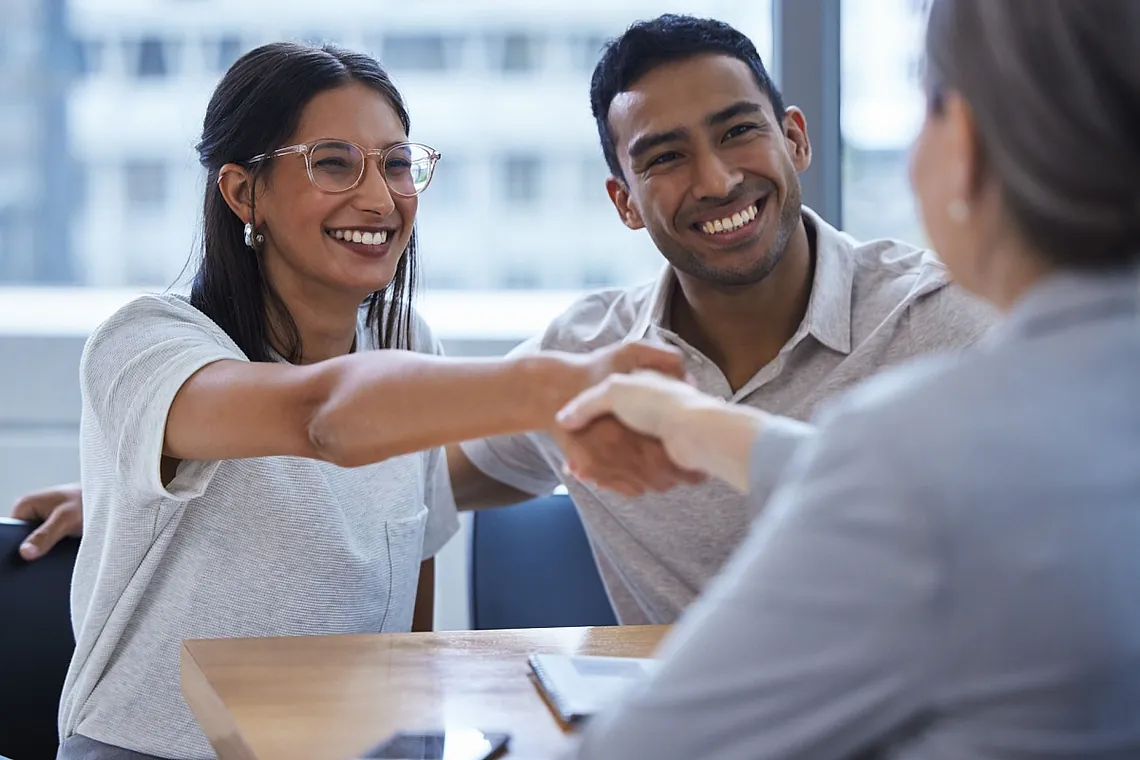 clients shaking hands with a female financial planner