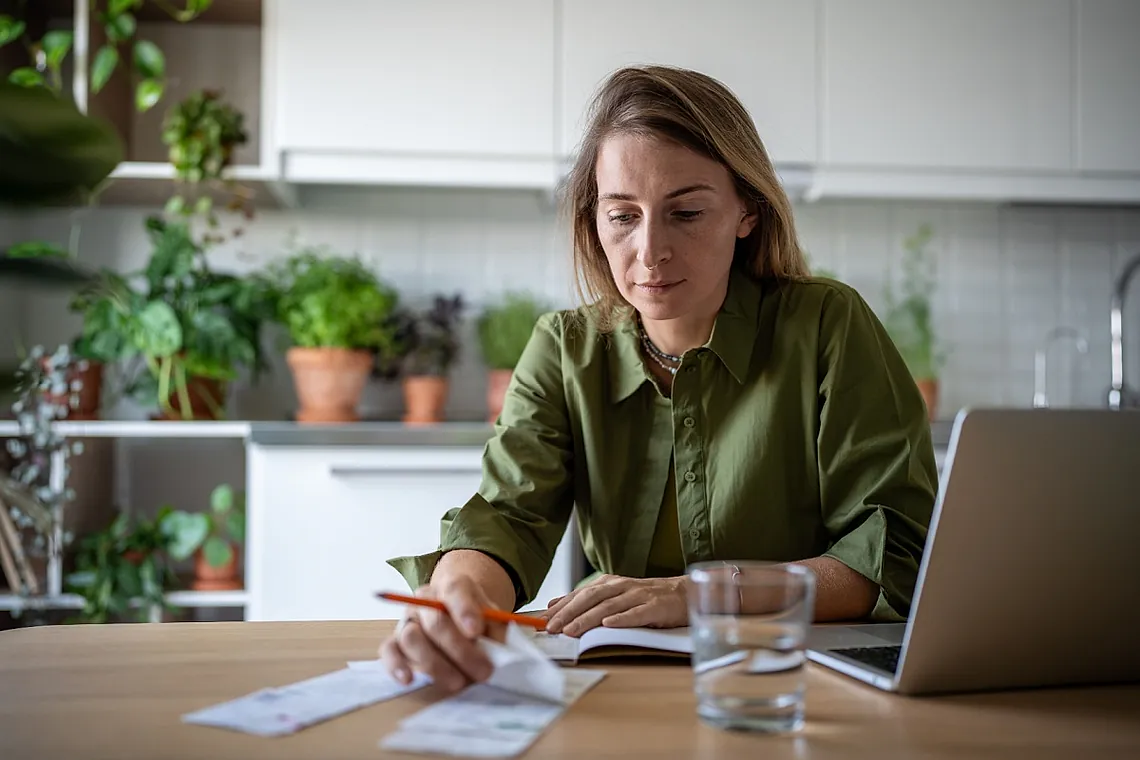 Woman looking at finances and laptop